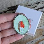 Load image into Gallery viewer, Messenger of sollace, a painted robin brooch
