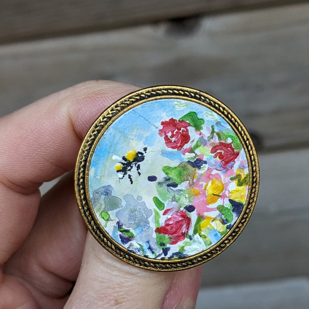 bee and roses painting on a brooch